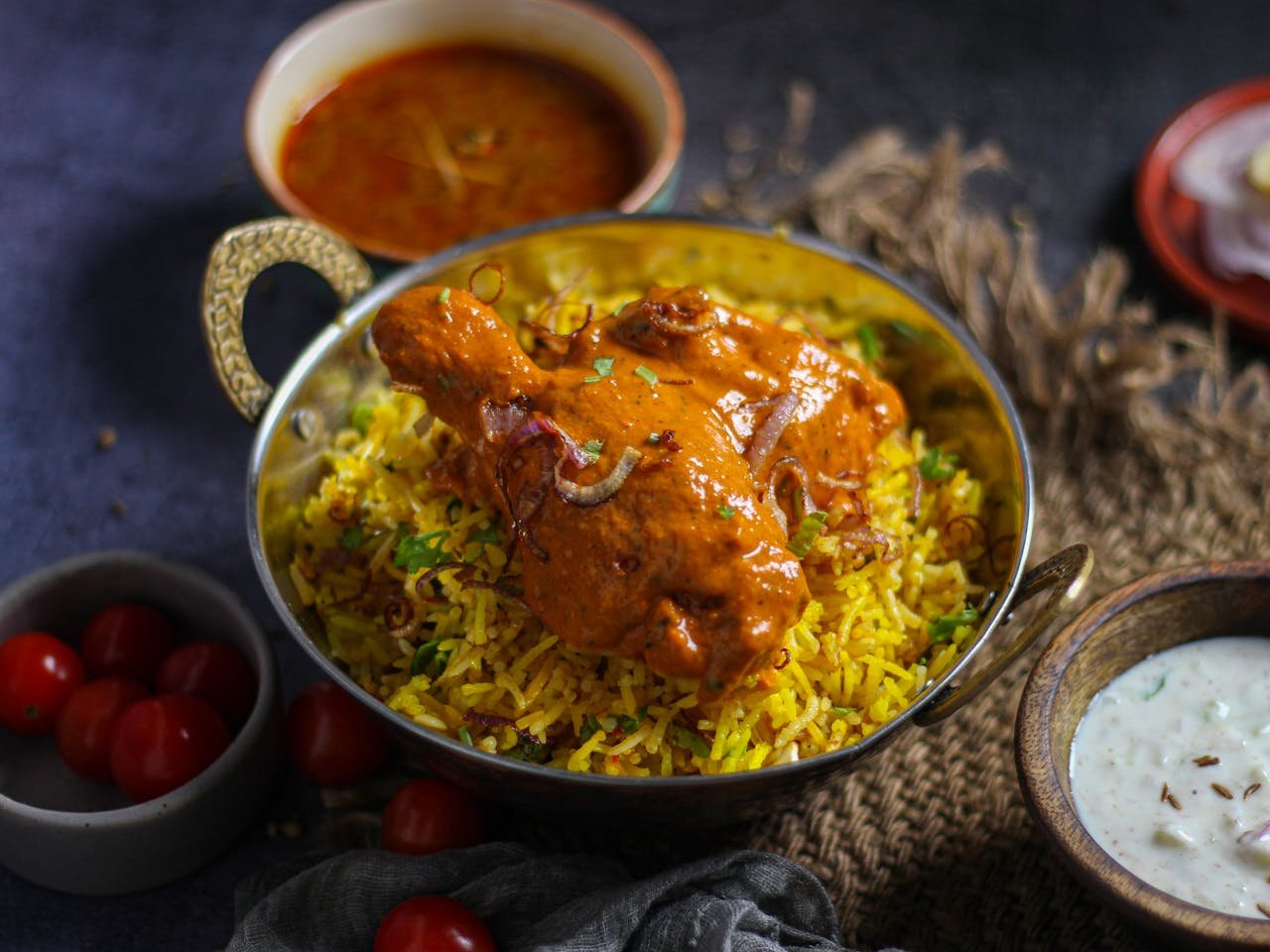 Delicious Indian chicken biryani served with accompanying curry and yogurt raita, capturing the essence of traditional cuisine.